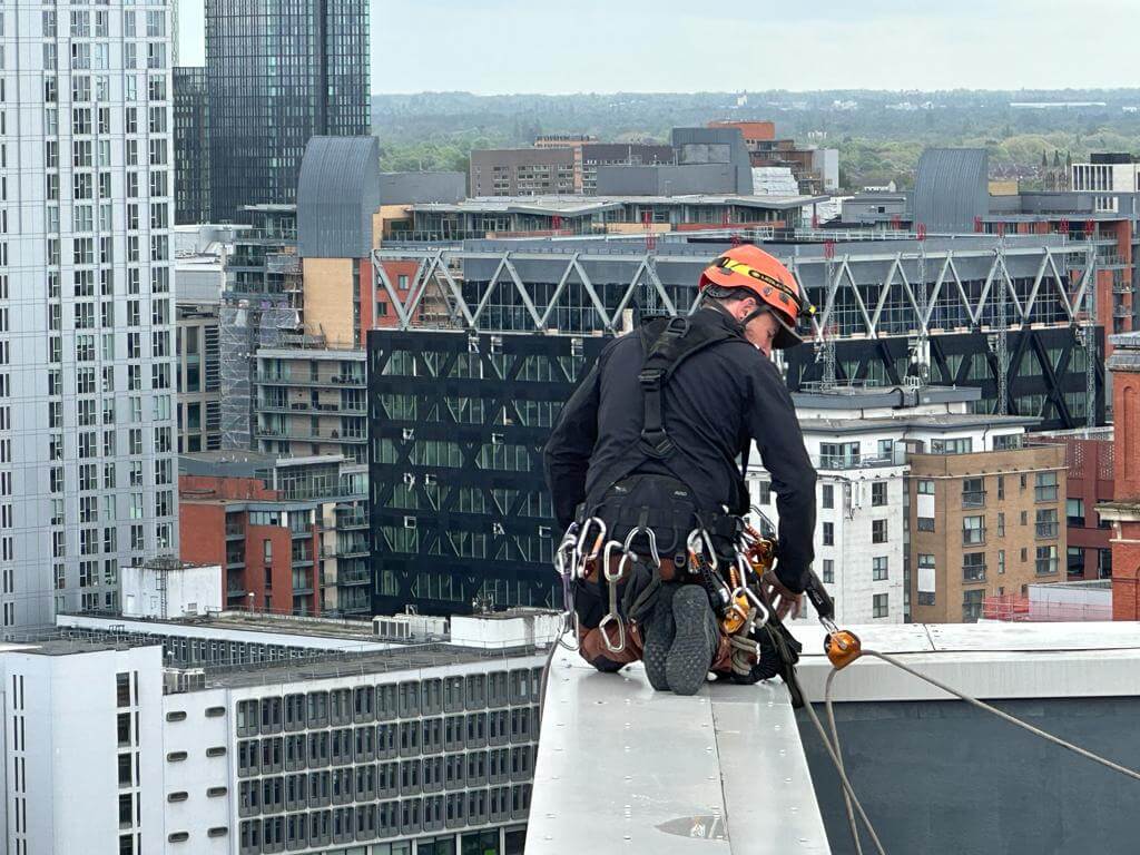 A man is cleaning a roof in a city.