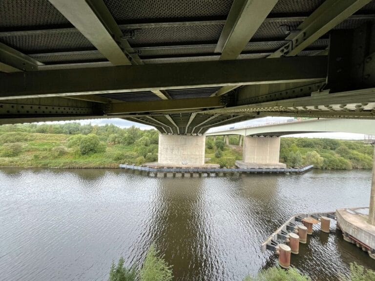 A bridge with roofing over a body of water.