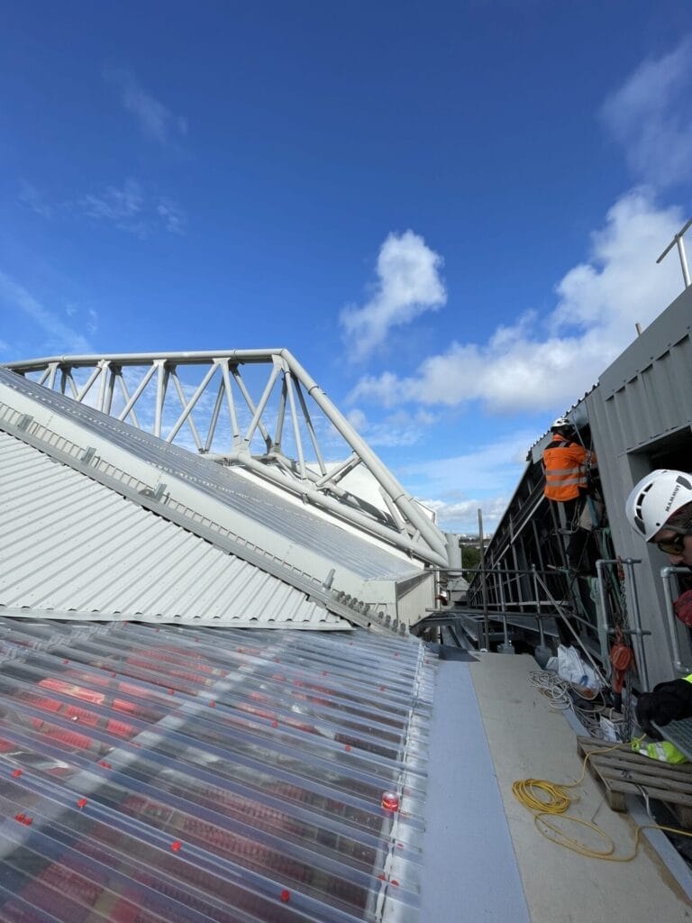 A roofing worker is working on the roof of a building.