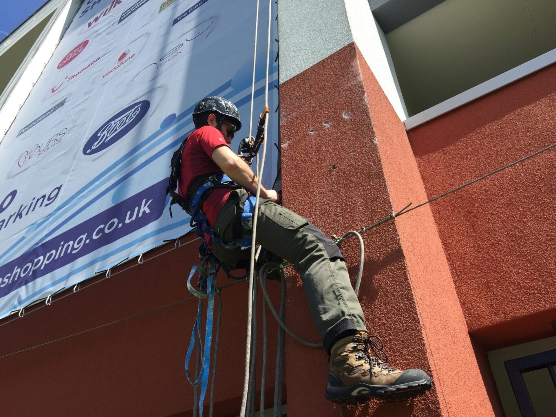 A man scaling the side of a building for an installation project.