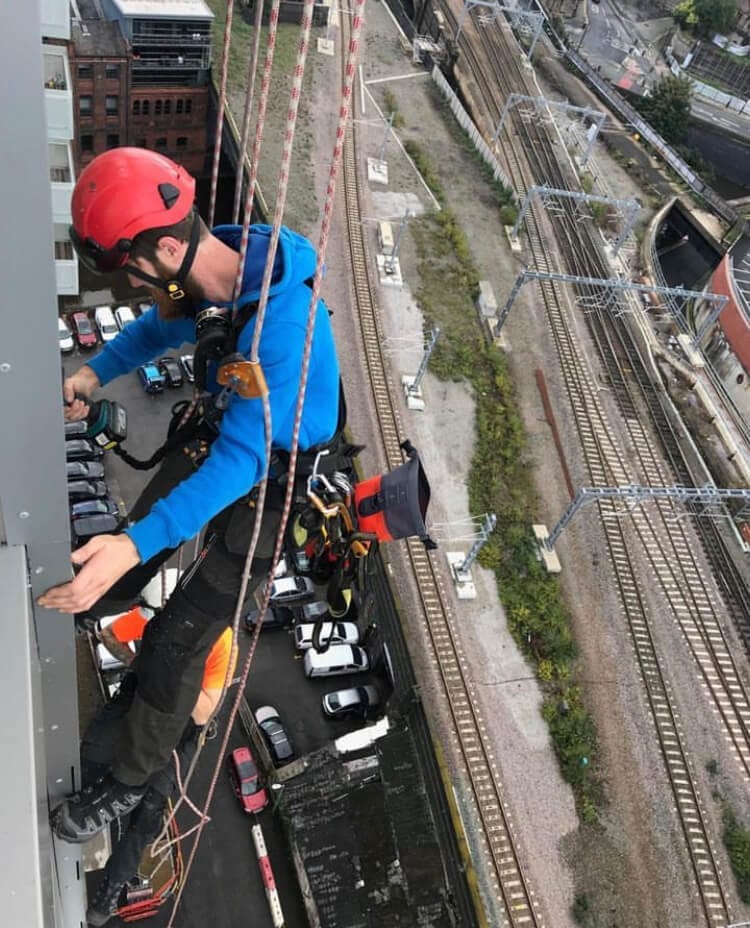 An important man in a helmet climbing a tall building, carefully navigating the facade.